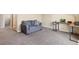 Comfortable living room area with gray sofa, desk, and ample carpet space at 5555 Perth Ct, Denver, CO 80249