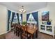 Bright dining room features a wood table, blue curtains, and a decorative wall art piece at 1682 Dorothy Cir, Longmont, CO 80503