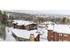 Ski condos with snow-covered roofs nestled amidst pine trees and mountains at 290 Broken Lance Dr # B202, Breckenridge, CO 80424