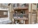 Stacked balconies on a timber building, with snow covered furniture and railings at 290 Broken Lance Dr # B202, Breckenridge, CO 80424