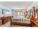 Inviting bedroom featuring a wooden bed, dresser, TV, and a view of the snow covered winter forest at 290 Broken Lance Dr # B202, Breckenridge, CO 80424