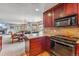 Open kitchen with wood cabinets, granite counters, and stainless appliances, flowing into living and dining areas at 290 Broken Lance Dr # B202, Breckenridge, CO 80424