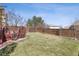 Spacious backyard featuring a well-maintained lawn, wooden fence, and a beautiful landscaped perimeter under a bright blue sky at 4901 Ashbrook Cir, Highlands Ranch, CO 80130
