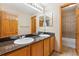Bathroom featuring double sinks, wood cabinets, and a decorative mirror at 4901 Ashbrook Cir, Highlands Ranch, CO 80130