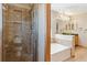 Modern bathroom featuring a glass shower, soaking tub, and tiled walls at 4901 Ashbrook Cir, Highlands Ranch, CO 80130