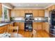 Kitchen features wood cabinets, black appliances and a table for dining at 4901 Ashbrook Cir, Highlands Ranch, CO 80130