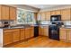Updated kitchen with wood cabinets, black appliances and a window over the sink at 4901 Ashbrook Cir, Highlands Ranch, CO 80130