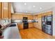 Spacious kitchen with stainless steel refrigerator, wood cabinets and black appliances at 4901 Ashbrook Cir, Highlands Ranch, CO 80130