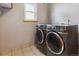 Laundry room showcasing modern washer and dryer units with tile floors at 4901 Ashbrook Cir, Highlands Ranch, CO 80130