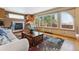 Comfortable living room with a fireplace, large windows, and view to the fenced deck at 4901 Ashbrook Cir, Highlands Ranch, CO 80130