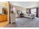 Bright main bedroom with carpet, a bed, nightstands, lamps and two windows with ensuite bathroom at 4901 Ashbrook Cir, Highlands Ranch, CO 80130