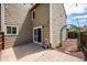 Exterior view of the home's backyard featuring a concrete patio, decorative arch, and sliding glass door at 10309 W Fair Ave # E, Littleton, CO 80127