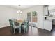 Bright dining room with a wooden table, blue chairs, and sliding glass doors to the outdoors at 10309 W Fair Ave # E, Littleton, CO 80127
