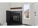 Close-up of a modern black-tiled fireplace with a rustic wood beam and a frosted window at 10309 W Fair Ave # E, Littleton, CO 80127