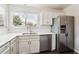 Well-lit kitchen with stainless steel appliances, white cabinets, and quartz countertops at 10309 W Fair Ave # E, Littleton, CO 80127