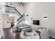 Bright living room boasts high ceilings, modern furnishings, and a staircase leading to the upper level at 10309 W Fair Ave # E, Littleton, CO 80127