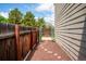 Pathway beside home leading to backyard, featuring decorative arch, mulch ground cover, and wood fencing at 10309 W Fair Ave # E, Littleton, CO 80127