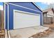 White garage door on a blue siding offering ample parking and a clean, modern look at 3429 W 34Th Ave, Denver, CO 80211