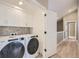 Laundry room with washer, dryer, and white cabinets at 6917 Kendrick Ln, Arvada, CO 80007