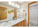 Well-lit bathroom featuring double sinks, framed mirrors and cabinets, and a separate shower room at 6726 W 97Th Cir, Westminster, CO 80021