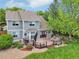 Back of house featuring a large deck and yard surrounded by mature trees, bushes and landscaping at 6726 W 97Th Cir, Westminster, CO 80021