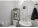 Cozy powder bathroom with a stylish round mirror, perfect for guests or quick touch-ups at 20932 E 60Th Ave, Aurora, CO 80019