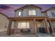 Charming two-story home featuring a covered front porch with stone accents and stylish gray siding, and beautiful dusk sky at 20932 E 60Th Ave, Aurora, CO 80019