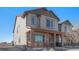 Charming two-story home featuring a covered front porch with stone accents and stylish gray siding at 20932 E 60Th Ave, Aurora, CO 80019