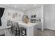 Modern kitchen island with bar seating, white quartz countertops, stainless steel appliances, and ample cabinet space at 20932 E 60Th Ave, Aurora, CO 80019
