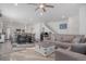 Bright, open-concept living space featuring a large sofa, modern decor, and seamlessly connected dining and kitchen areas at 20932 E 60Th Ave, Aurora, CO 80019