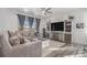 Cozy living room featuring a large sofa, entertainment center, and natural light streaming through the window at 20932 E 60Th Ave, Aurora, CO 80019