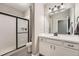Bathroom features a tile shower with sliding glass door, white vanity, and black hardware at 7693 S Quantock Way, Aurora, CO 80016