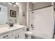 Bathroom features a white vanity with stone countertop, framed mirror and bathtub with shower at 7693 S Quantock Way, Aurora, CO 80016