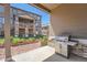 Covered patio offers a grill for outdoor cooking with a view of landscaped yard and neighboring home at 7693 S Quantock Way, Aurora, CO 80016