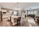 Open-concept kitchen flowing into the living area with a large island, stainless steel appliances, and hardwood floors at 7693 S Quantock Way, Aurora, CO 80016