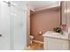 Updated bathroom with a modern vanity, shower, and toilet, complemented by tasteful rose-colored walls at 6545 Union St, Arvada, CO 80004