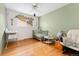 Bright Bedroom with hardwood floors features a crib, changing table, and a plush glider chair at 6545 Union St, Arvada, CO 80004