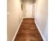 Long hallway with neutral paint and plank flooring leading to the front door at 13890 E Marina Dr # 602, Aurora, CO 80014