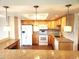 A well-lit kitchen with wood cabinets, granite countertops, and white appliances at 13890 E Marina Dr # 602, Aurora, CO 80014