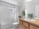 A clean, bright bathroom with a shower-tub combo, white tile, and a well-lit vanity at 8450 E 29Th Ave, Denver, CO 80238
