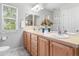 Bright bathroom featuring double sinks, lots of natural light, and a large vanity with storage at 8450 E 29Th Ave, Denver, CO 80238