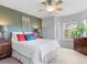Cozy bedroom with a stylish macrame wall hanging, two-tone paint, and bright windows at 8450 E 29Th Ave, Denver, CO 80238
