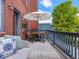 Outdoor dining on a cozy deck with a table and chairs, shaded by a white umbrella at 8450 E 29Th Ave, Denver, CO 80238