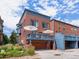 A brick townhouse features a spacious deck above a garage, offering a stylish exterior at 8450 E 29Th Ave, Denver, CO 80238