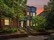 Charming brick home with landscaped front yard, covered porch, and blue trim under a colorful sky at 8450 E 29Th Ave, Denver, CO 80238