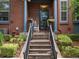 Inviting front porch with concrete stairs, black metal railing, brick facade, and flower planters at 8450 E 29Th Ave, Denver, CO 80238