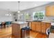 Bright kitchen with wood cabinets, an island, stainless appliances, and a view of the dining area at 8450 E 29Th Ave, Denver, CO 80238