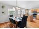 Open-concept kitchen with an island, modern appliances, dining area, and backyard access at 8450 E 29Th Ave, Denver, CO 80238