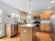 Well-lit kitchen with wood cabinets, an island, stainless appliances, and a view of the backyard at 8450 E 29Th Ave, Denver, CO 80238