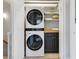 A modern laundry closet features stacked washer and dryer, shelving, and a butcher block folding counter at 8450 E 29Th Ave, Denver, CO 80238